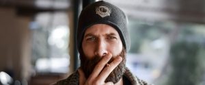 a bearded hipster smoking a cigarette