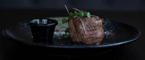 cooked beef on a black plate