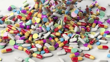 large amount of antimicrobial pills cascading onto a white surface