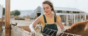 a female farmer getting hay for the horses