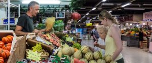 two women shopping in at a fruit and vegetable stand