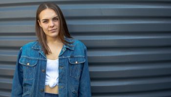 a woman in front of a blue wall