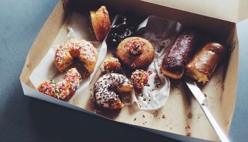 a box with a mixture of chocolate and sugared donuts