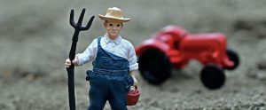 toy farmer with tractor in background