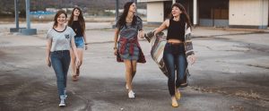teenage girls walking together in a derelict gas station
