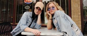 two women sitting outside a cafe