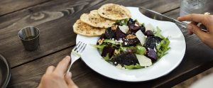 a person eating from a bowl of vegetarian food