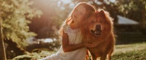 a young girl hugging her pet dog