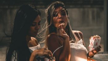 two women eating popcorn together