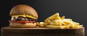 cheeseburger and fries on a wooden tray