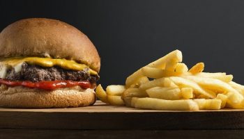 cheeseburger and fries on a wooden tray