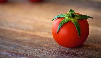 fresh wet tomato on wooden cutting board