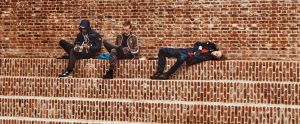 three young adults sitting on brick steps