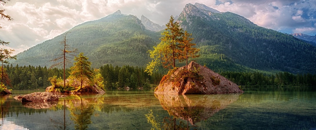 lake in front of a wooded mountain range