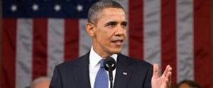 Barack Obama giving a speech with an American flag behind him