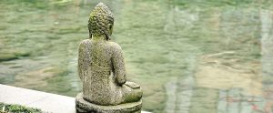 a buddhist statue near a pond