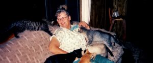 cat hoarder on a sofa surrounded by her cats