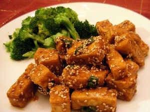 sesame-glazed tofu and steamed broccoli on a white plate