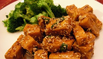 sesame-glazed tofu and steamed broccoli on a white plate
