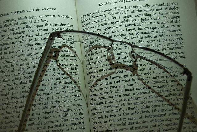 pair of glasses on an open book, entitled, "Social Construction of Reality"