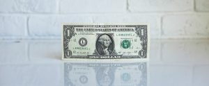 a dollar bill with a white wall behind it