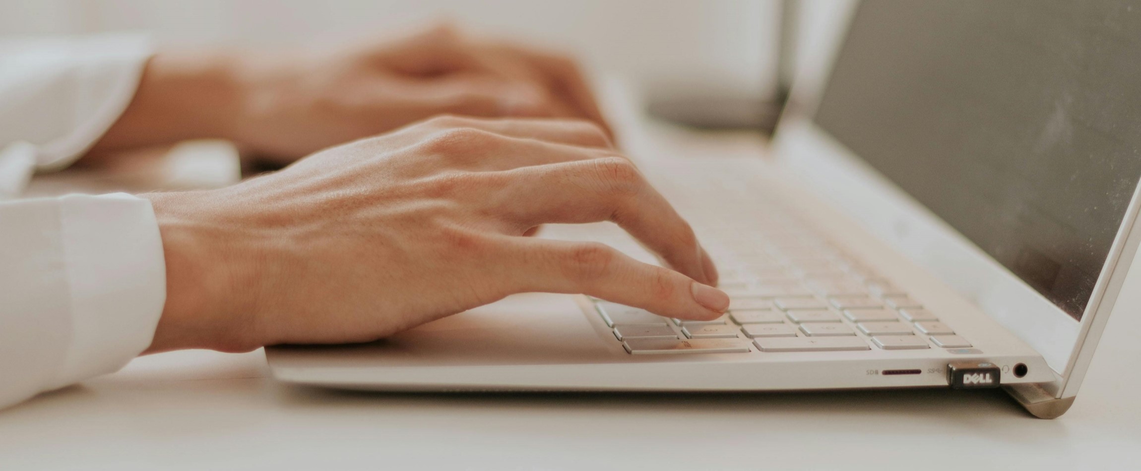 hands typing on silver laptop