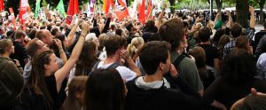 people demonstrating for political change with flags