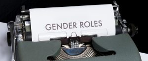 Typewriter with a piece of paper saying "gender roles"