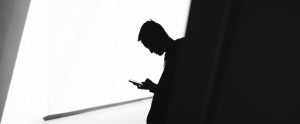person reading their phone in the shadows