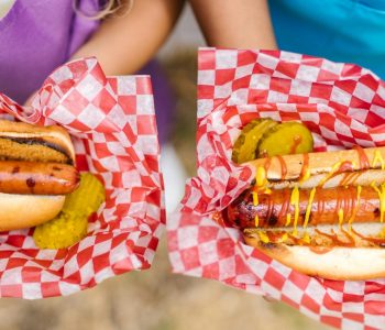 kids hands holding hotdogs