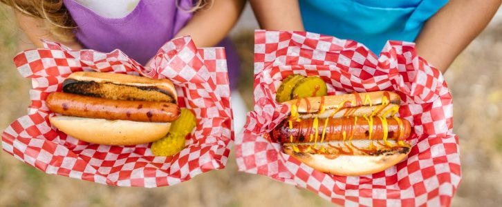 kids hands holding hotdogs