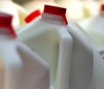 plastic jugs of milk at grocery store