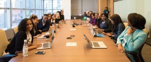people sitting around long meeting table at work