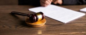 gavel on desk with person signing papers
