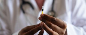 close-up of doctor hands holding syringe with needle