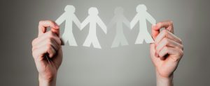 hands holding up paper doll chain