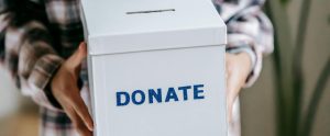 hands holding white donation box