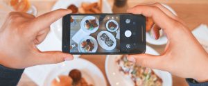 person taking picture of food with phone