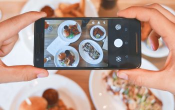 person taking picture of food with phone