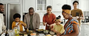 family standing around kitchen island eating together