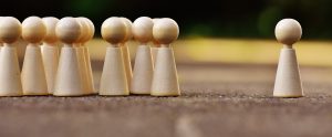 group of wooden figures with one standing alone