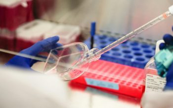 researcher measuring volume of cell cultures for experiment