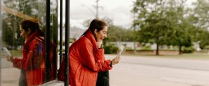 person outdoors looking at phone laughing