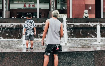 man and child standing next to outdoor fountain Ngee Ann City Singapore