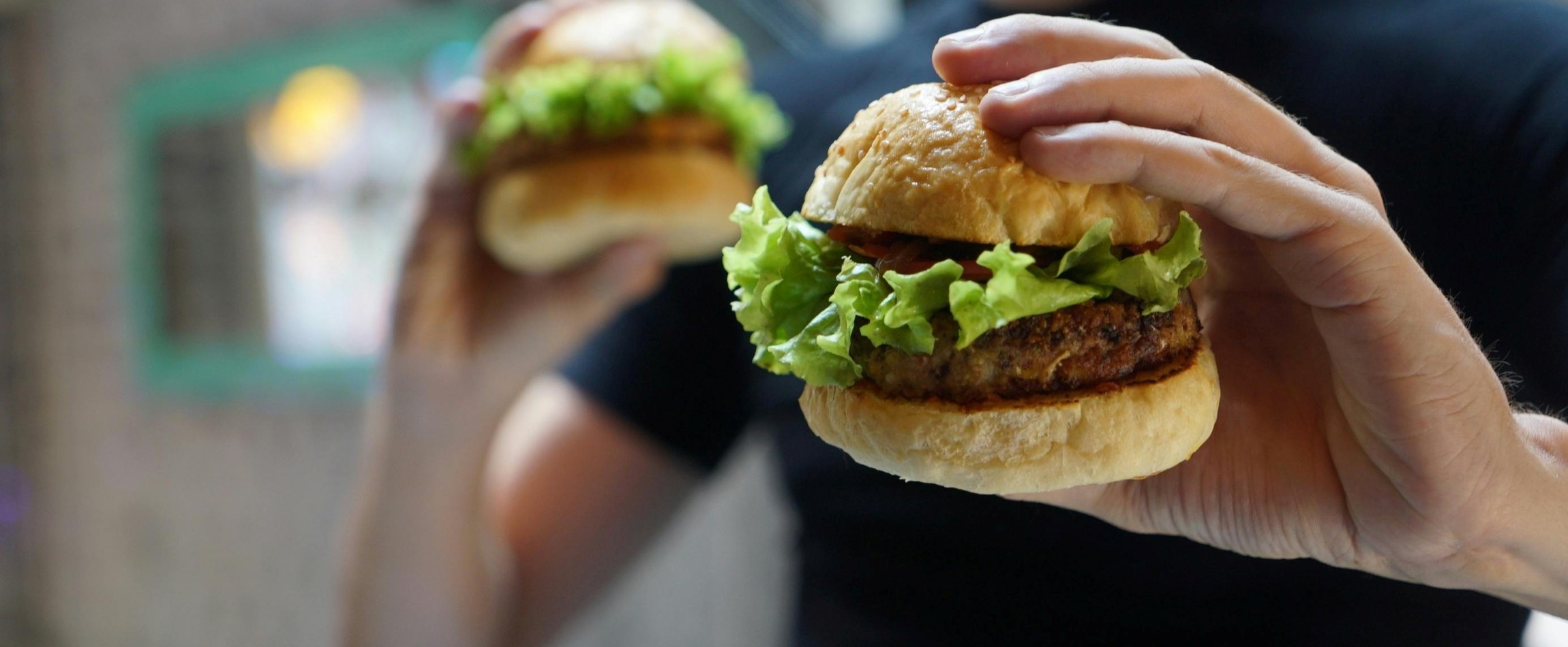 close-up of hand holding hamburger
