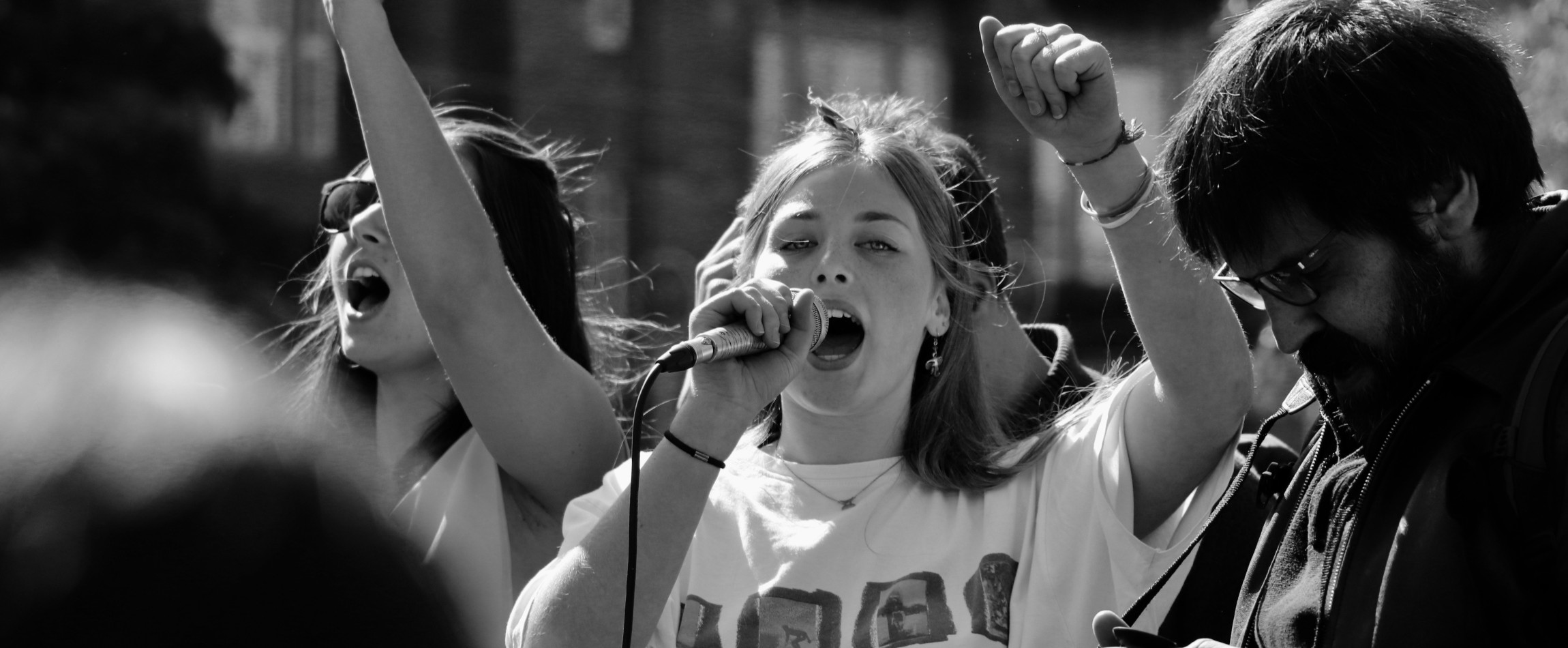 person shouting into microphone protest black and white