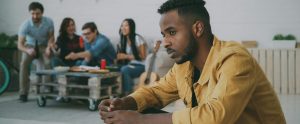 person feeling left out while friends eat in background