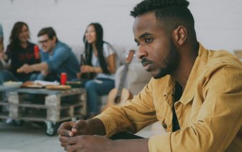 person feeling left out while friends eat in background