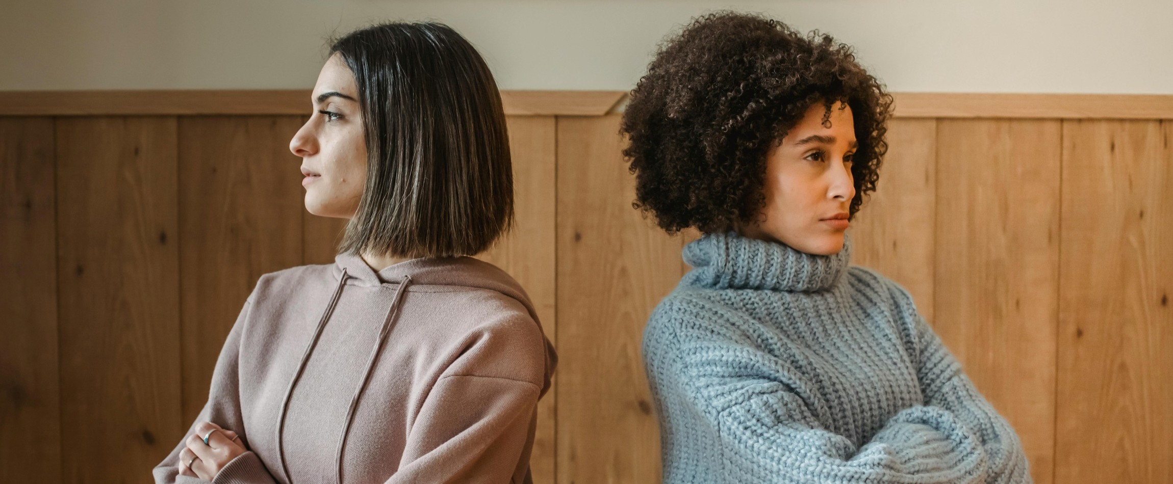 two people standing back-to-back with arms crossed