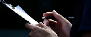 close-up of hands holding pen and clipboard
